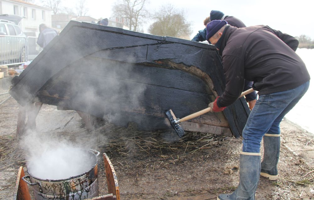 Goudronnage de la coque pour protéger le bois et le calfatage.